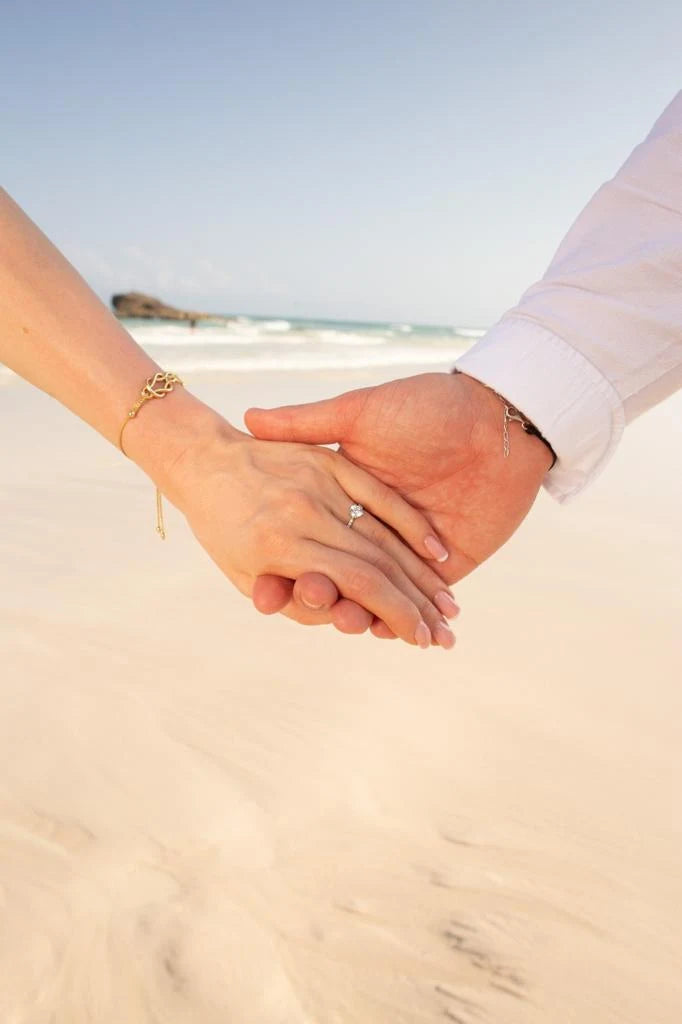 pierscionek zareczynowy z diamentem 0,80ct na plaży na splecionych dłoniach